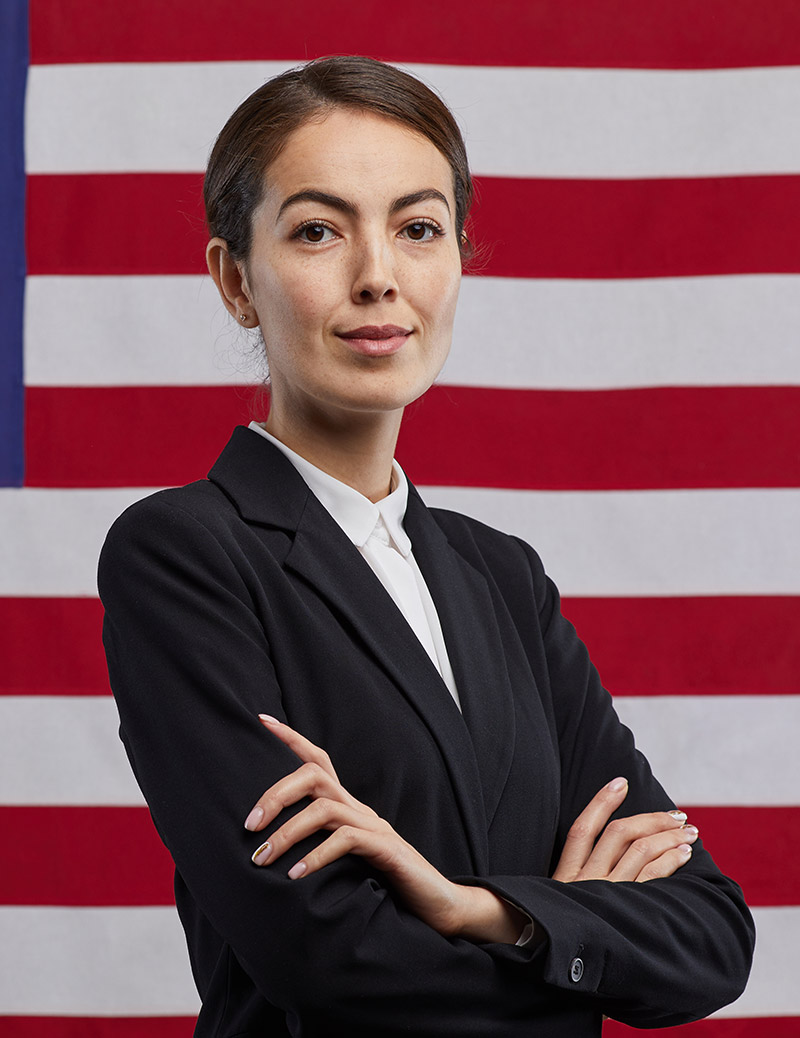 confident-female-politician-against-american-flag-QPRLRJ4
